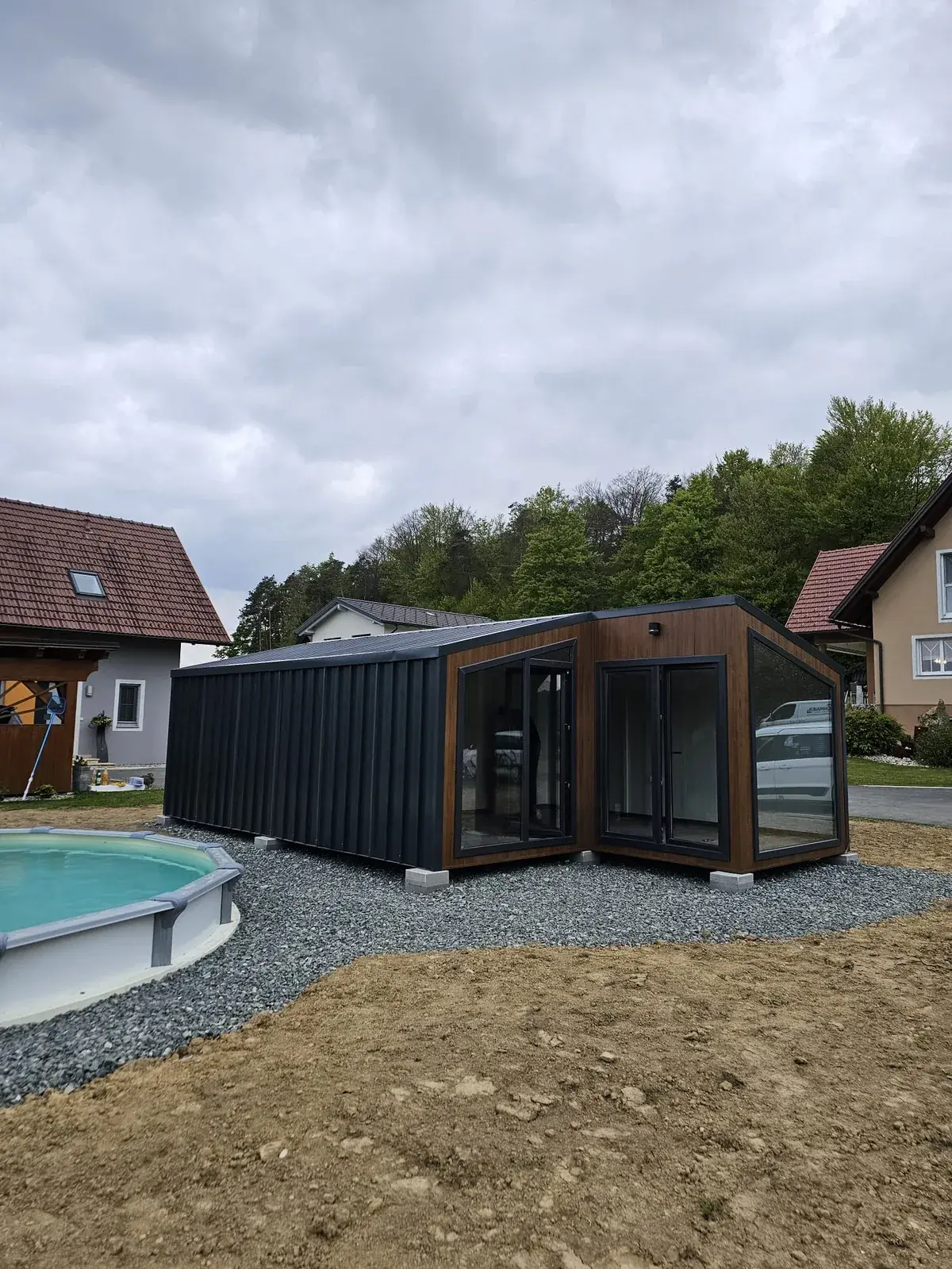 Tiny house uz bazen s kliznim staklenim stijenama